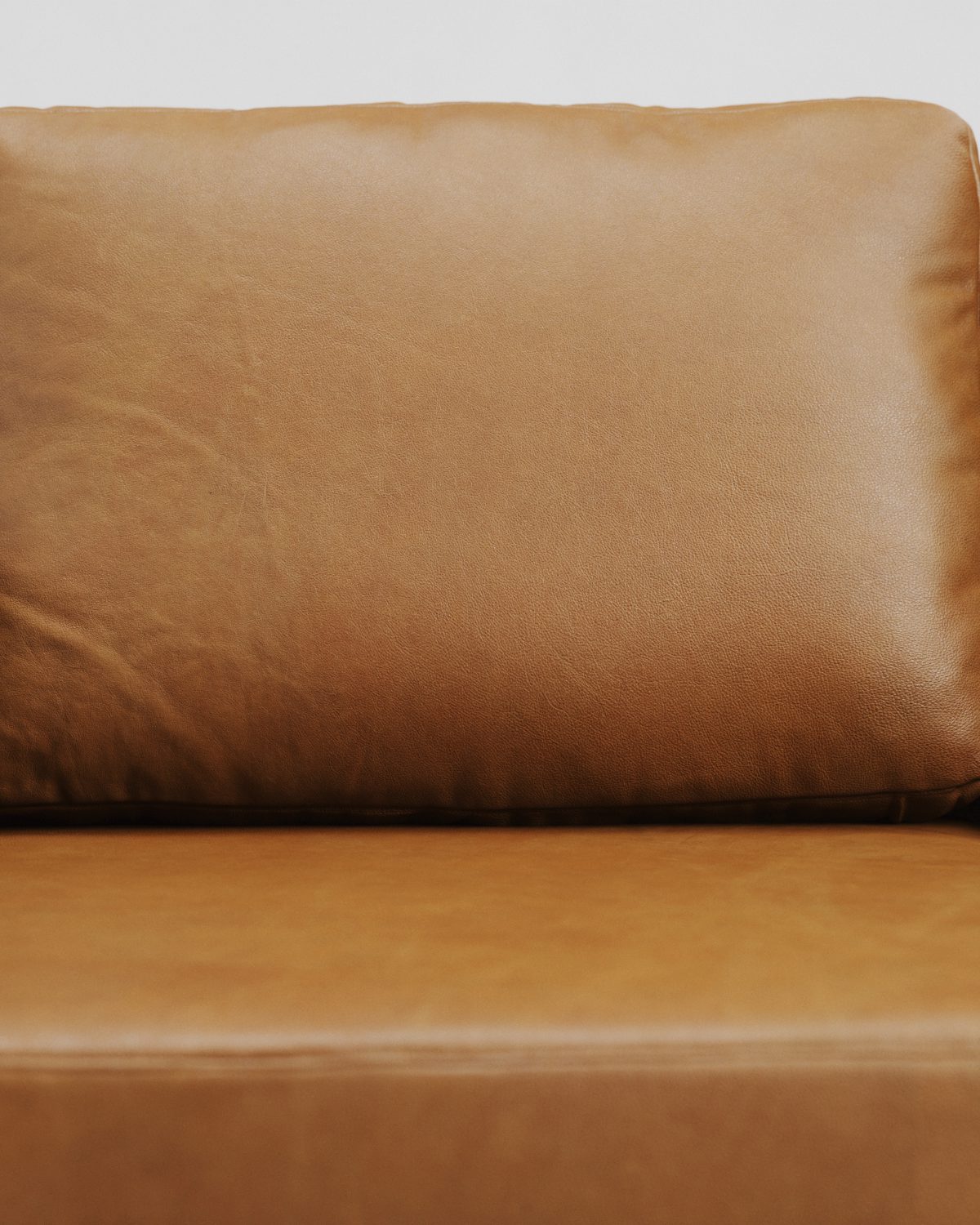 Tan leather sofa seat and arm with soft creases in the leather
