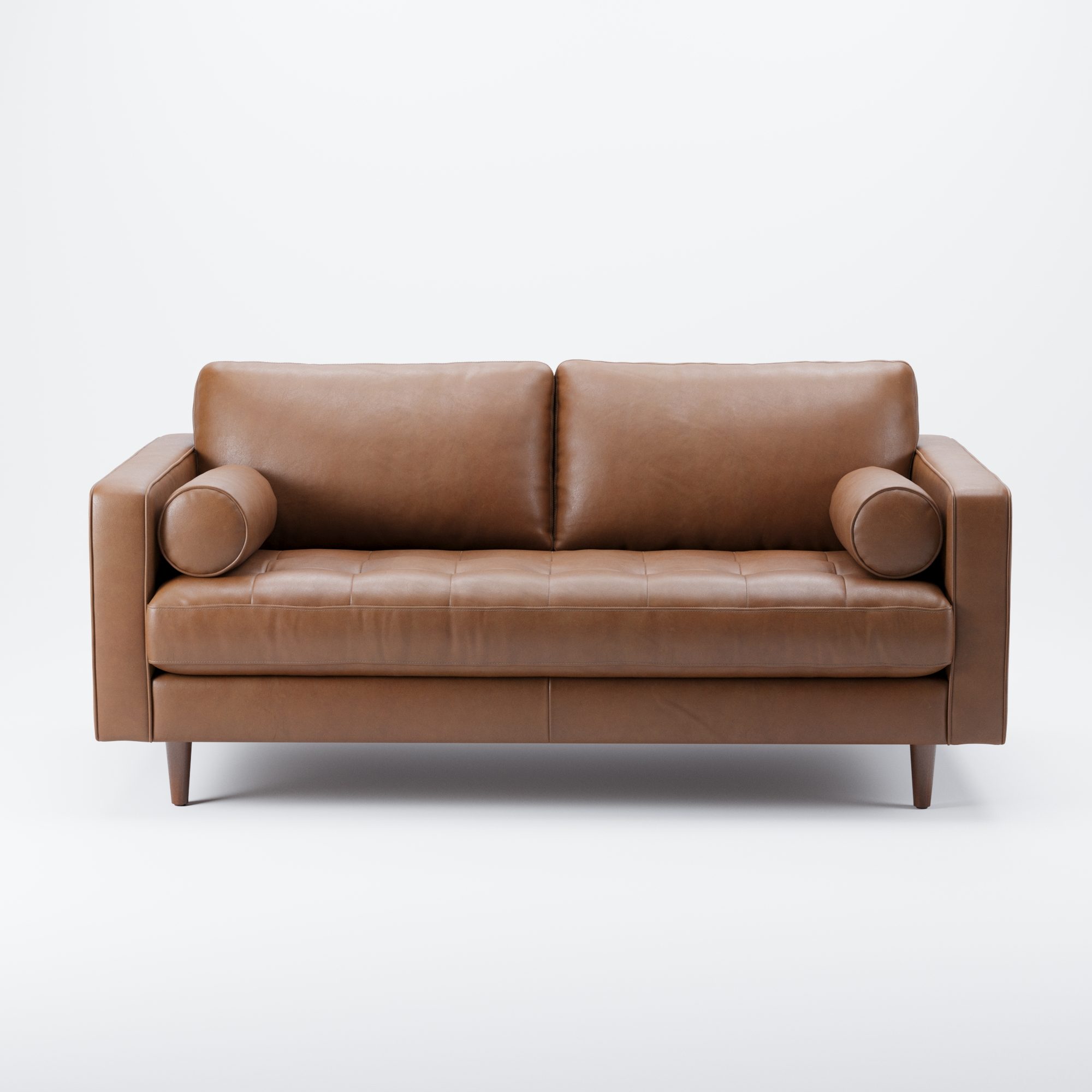 Tan leather sofa with bolster cushions seen from the front on a pale grey background