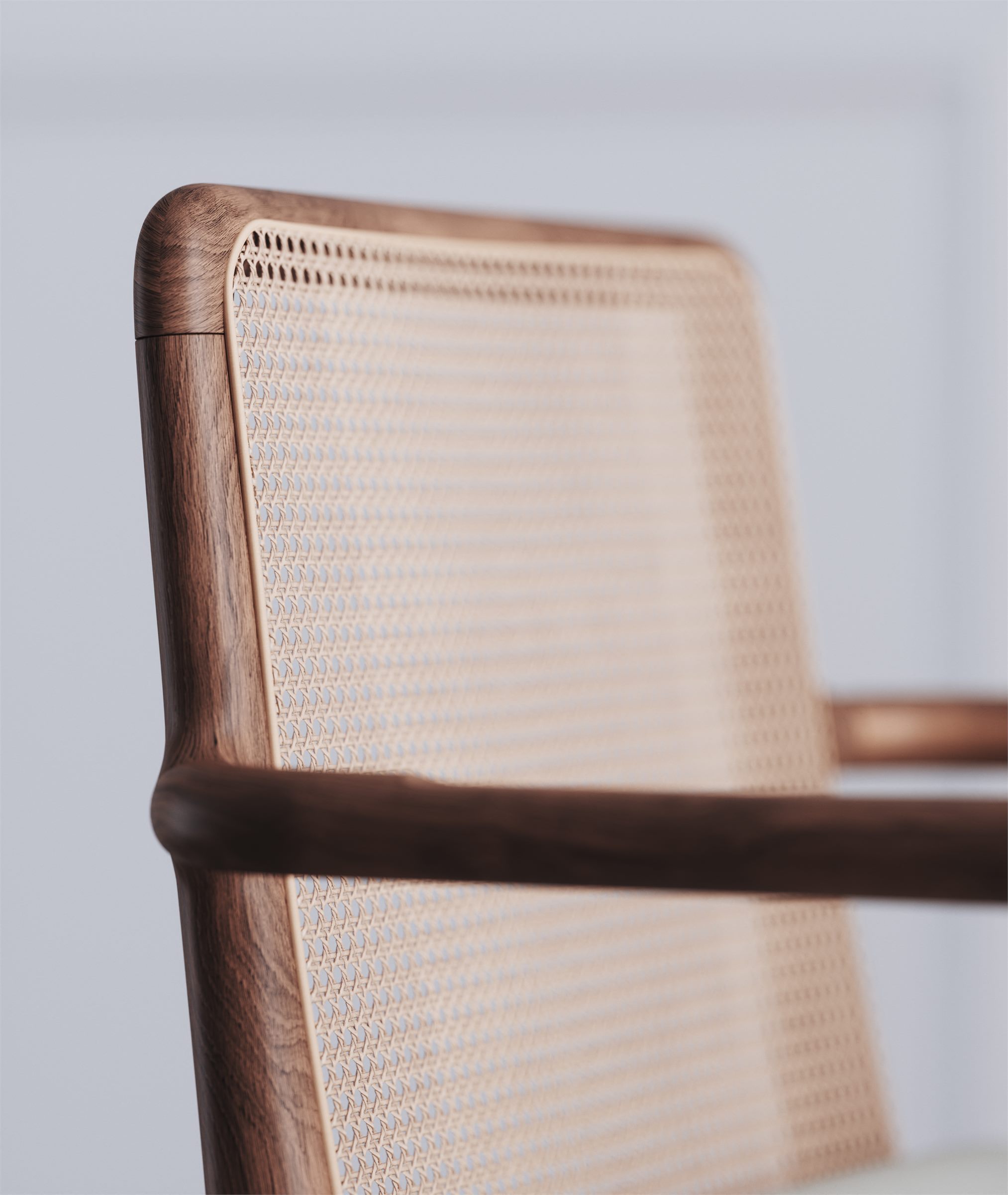 Close-up of a wooden chair frame with a woven cane back