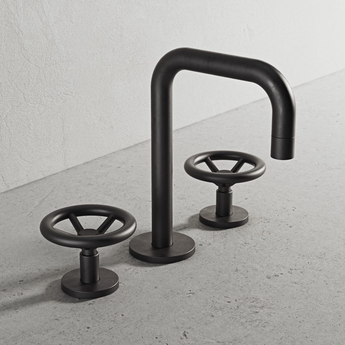 Matte black basin tap with two wheel handles on a concrete surface